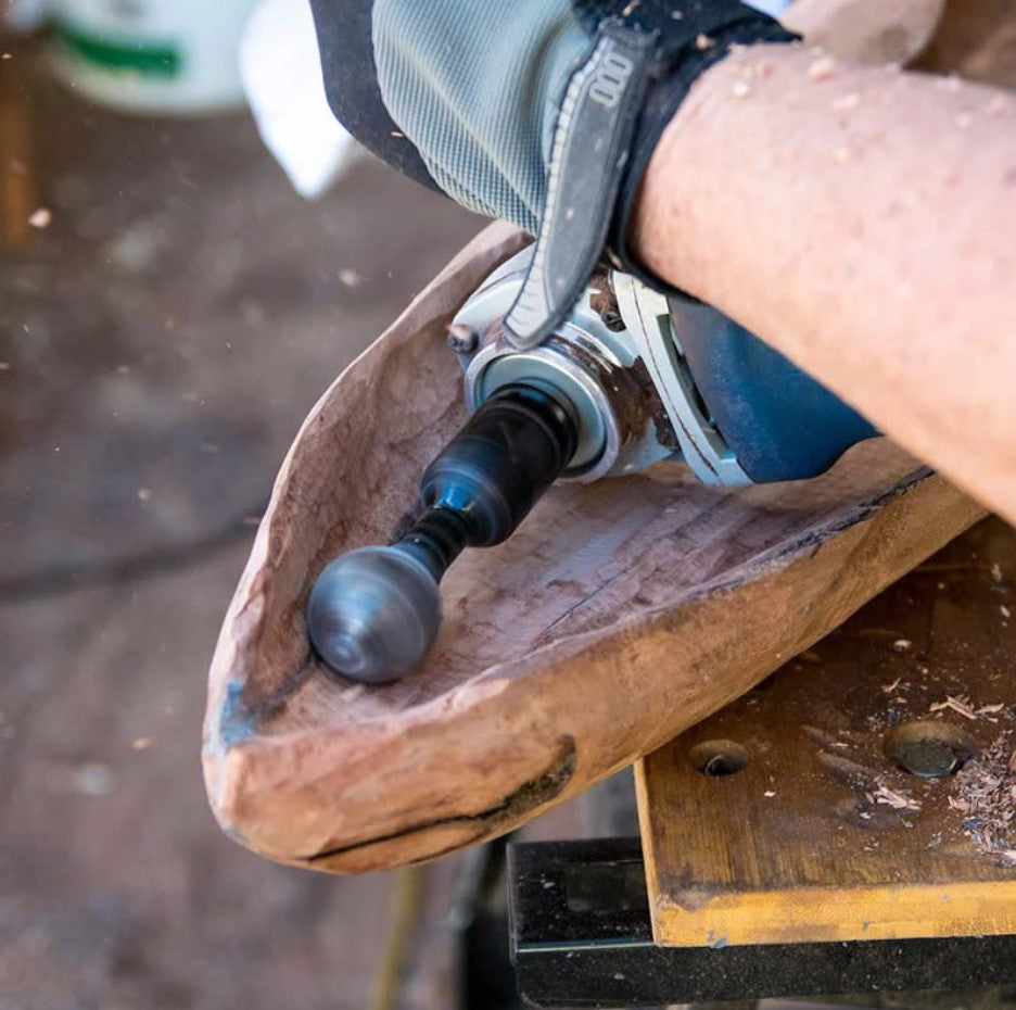 Gloved hand using a grinder with a spherical bit to hollow out a rough wooden bowl 3