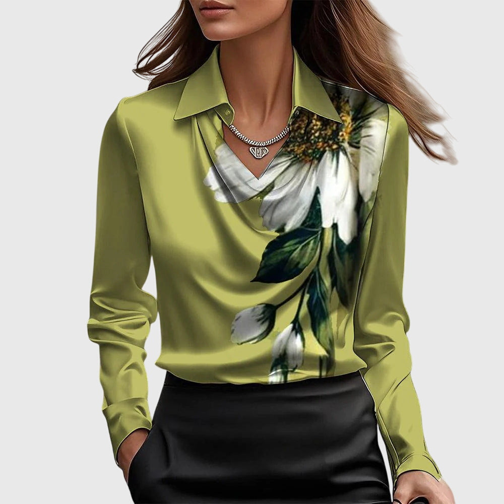 Model wearing the olive-green satin cowl-neck blouse with a large white flower and green leaves printed down the right side. 7