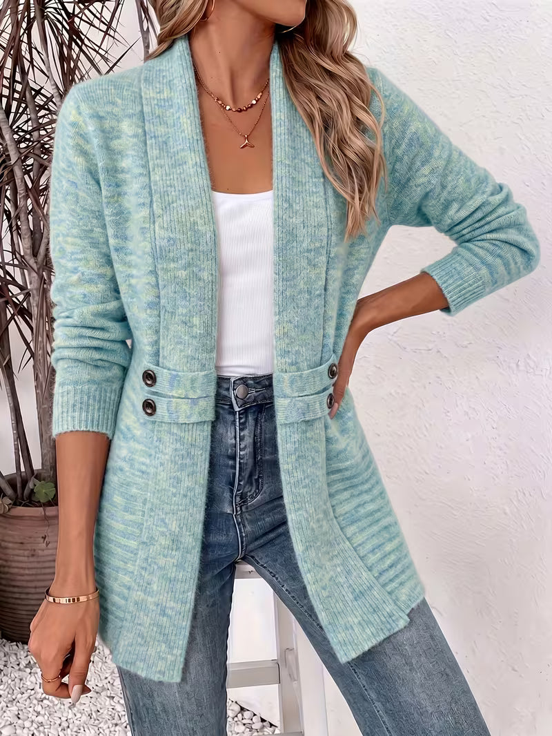 Model wearing the mottled blue-green cardigan open over a white top and jeans, one hand on hip 5