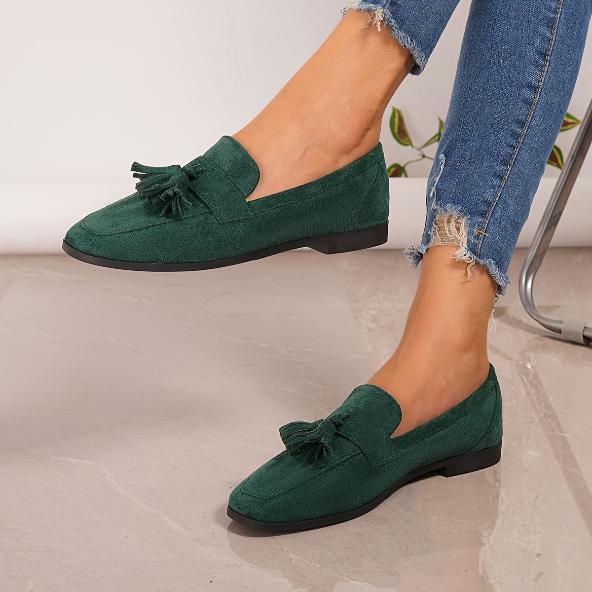 Green tasselled loafers worn with frayed-hem jeans, one foot lifted to show the side profile 10