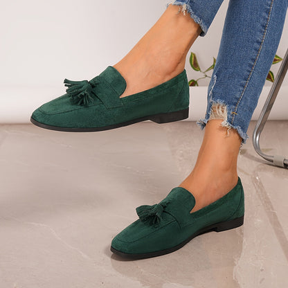 Green tasselled loafers worn with frayed-hem jeans, one foot lifted to show the side profile 10