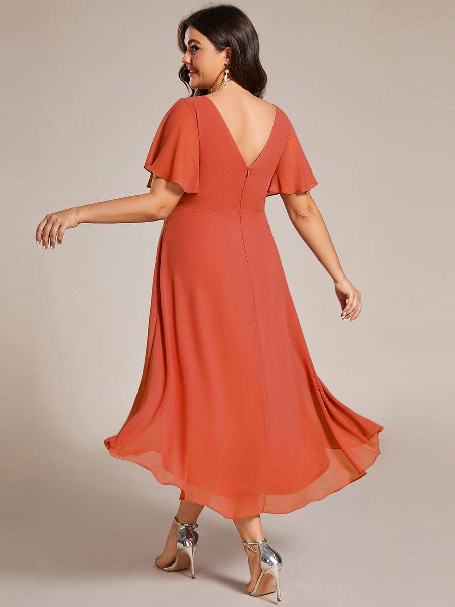 Back view of the burnt orange chiffon dress on a plus-size model, showing the deep V back and flowing hem. 98