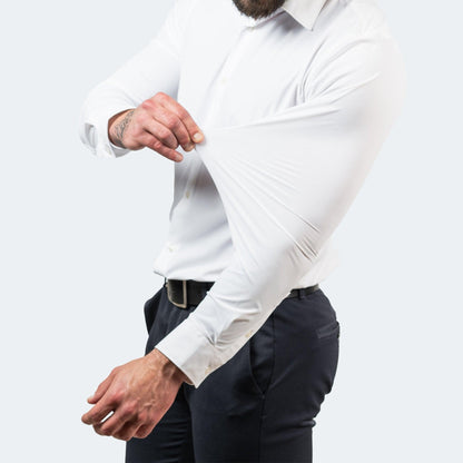 Model in a white shirt with navy trousers stretching the sleeve out from the forearm, showing the stretch at the arm. 4