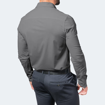 Back view of a model in a grey long-sleeved shirt tucked into navy trousers with a black belt, showing the smooth back panel. 6