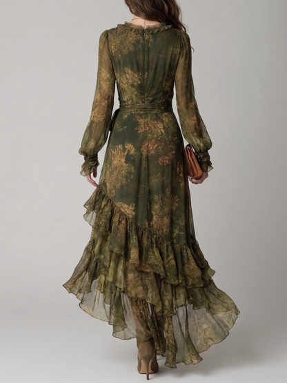 Back view of the dress on a model, showing the concealed zip, ruffled neckline, waist tie and cascading asymmetric ruffle tiers. 2