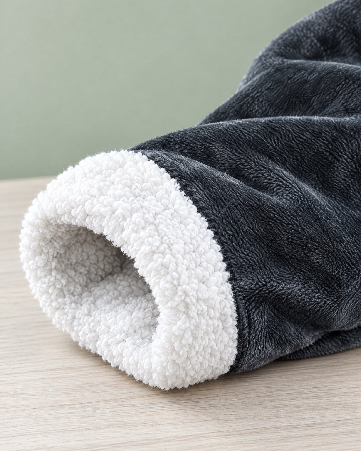 Close-up of a sleeve cuff turned back to show the soft white sherpa lining against the charcoal fleece outer. 8