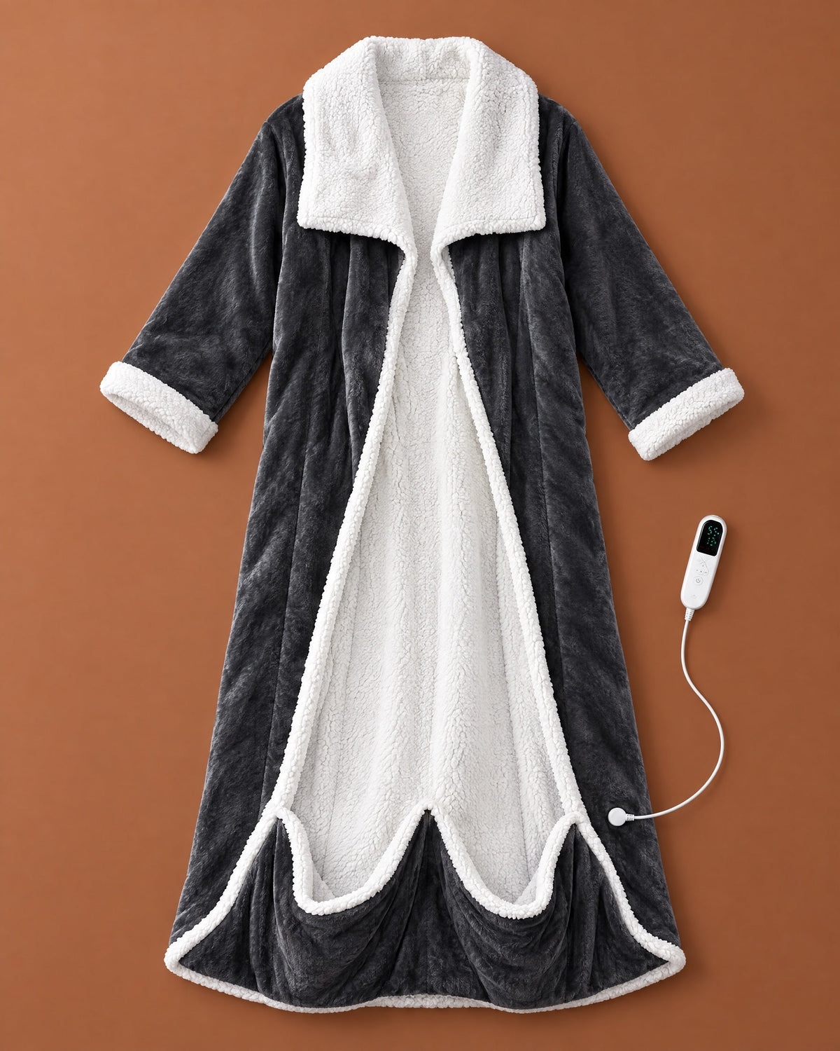 Flat lay of the open charcoal fleece robe with white sherpa collar, cuffs and lining, plus its white heat controller on a rust background. 1