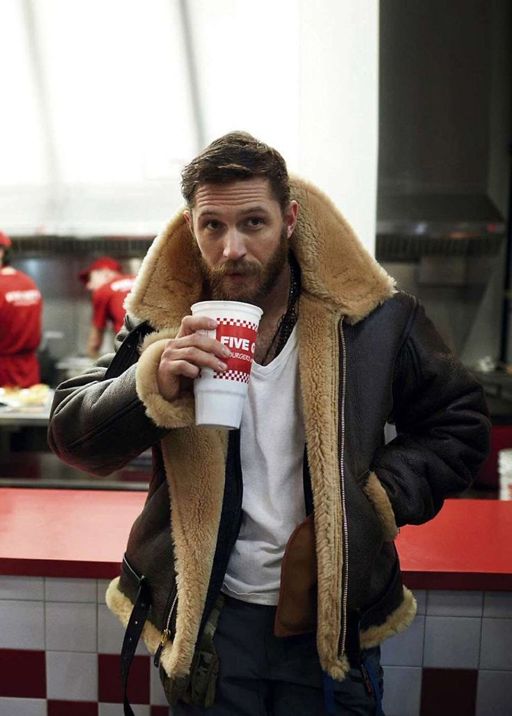Bearded man wearing the jacket over a white t-shirt, holding a paper cup in a diner 4