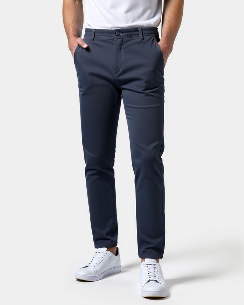 Navy slim chinos worn by a model with a white t-shirt and white trainers, both hands in the front pockets. 15