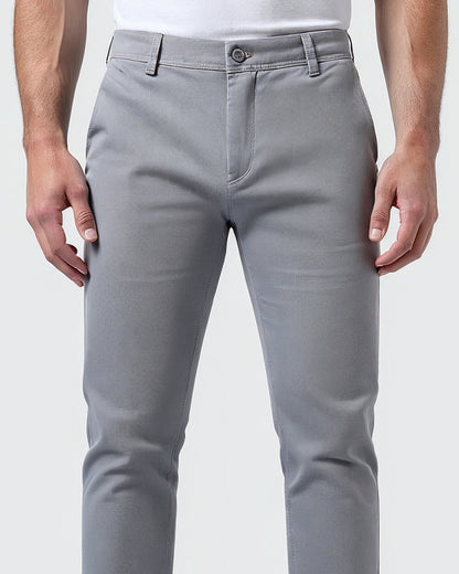 Close-up of light grey chinos at the waist, showing the button fastening, fly, belt loops and fabric texture. 5