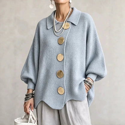 Pale blue ribbed cardigan on a model, with large gold buttons and scalloped hem, styled with light grey trousers. 5