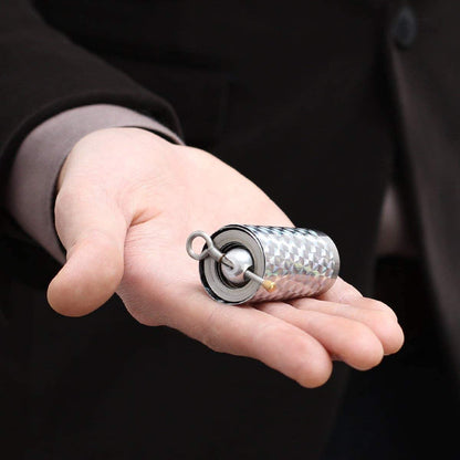 Compact wand case with coiled metal band resting on an open palm, held by a man in a dark suit 1