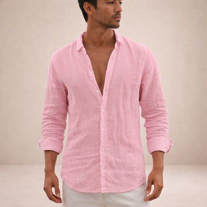 Model in a pink linen shirt with sleeves rolled up, front view, glancing to the side against a neutral backdrop. 1