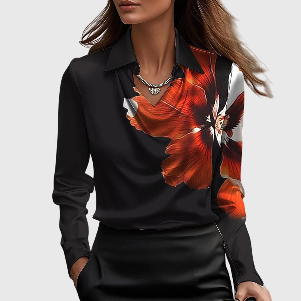 Model wearing the black cowl-neck blouse with a large orange and white flower printed across one shoulder and the chest. 6
