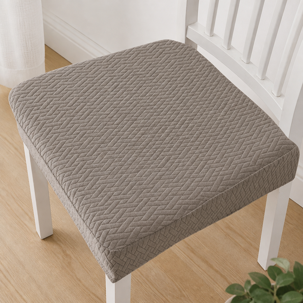 Taupe seat cover with a raised herringbone weave, seen from above on a white slatted chair. 12