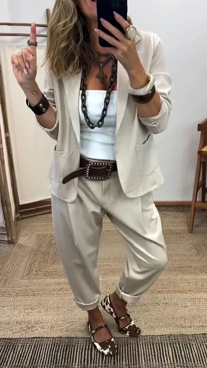 Mirror selfie of the pale beige blazer and matching loose trousers with turned-up hems, worn with a white top and chunky chain necklace. 2