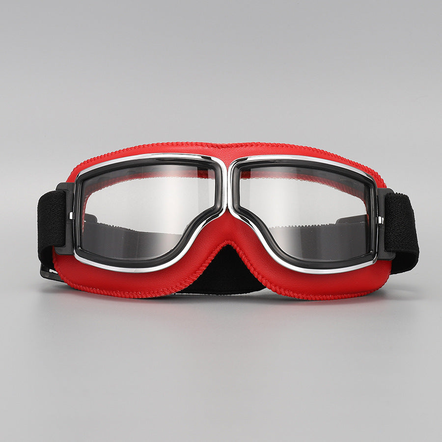 Front view of the goggles with bright red padding, chrome-trimmed frame, clear lenses and a black elastic strap. 10