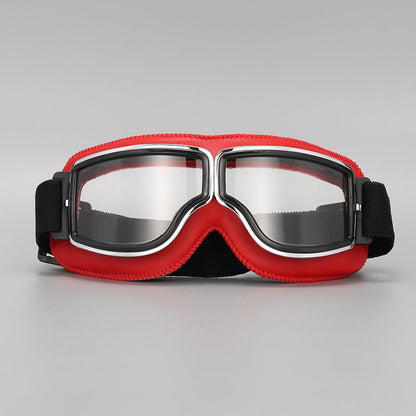 Front view of the goggles with bright red padding, chrome-trimmed frame, clear lenses and a black elastic strap. 10