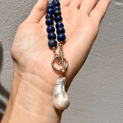 Close view in a palm of the blue beads, rose-gold toggle clasp and large baroque pearl 3