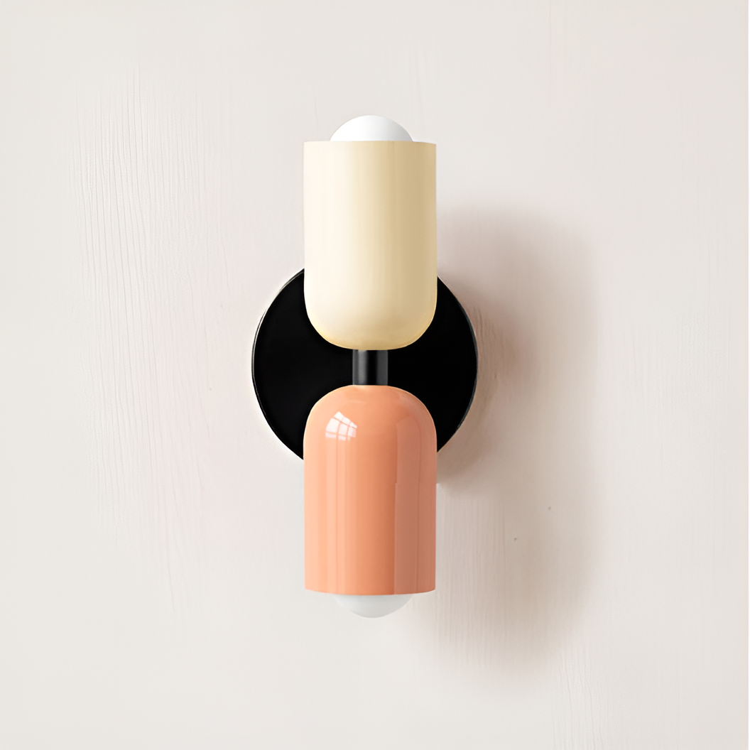 Wall light with a cream upper head and peach lower head on a round black backplate. 33