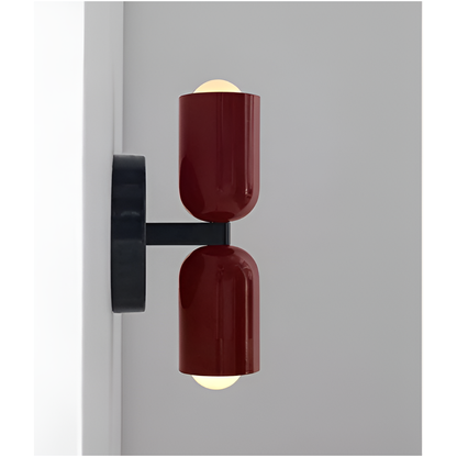 Side view of a wall light with two deep red heads on a black arm, showing how far it projects from the wall. 17