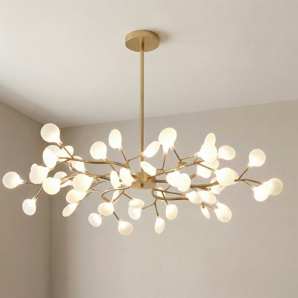 Large gold branch chandelier with glowing frosted orbs, photographed in a room corner at an angle 11