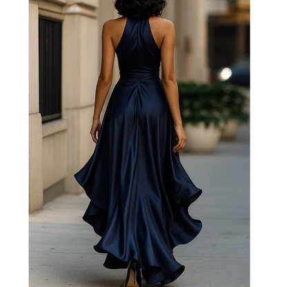 Back view on a model of the navy satin halter dress, with high neck, open shoulders and flared ruffle hem. 8