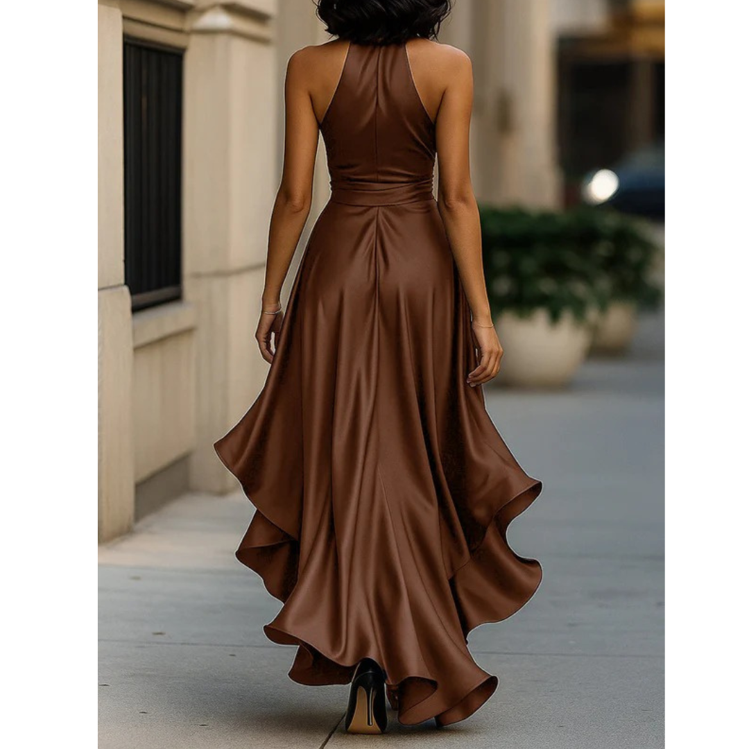 Back view on a model of the brown satin halter dress, showing the smooth back panel and cascading ruffle hem. 11