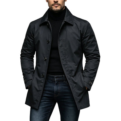 Model wearing the coat in black, buttoned over a black polo neck and dark jeans 1