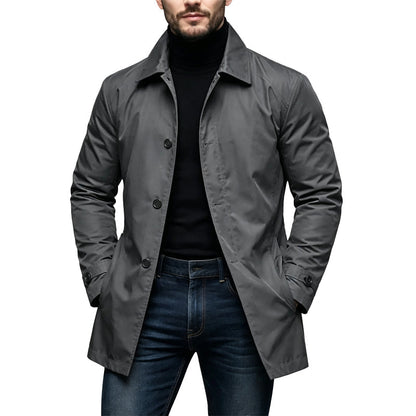 Model wearing the coat in charcoal grey, with hands in pockets, over black polo neck and jeans 2