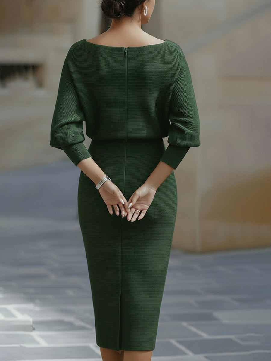 Back view of the dark green midi dress on a model, showing the centre back zip, sleeve cuffs and skirt slit. 10