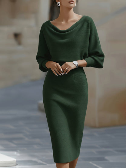 Front view of the midi dress in dark green on a model, with draped neckline and fitted ribbed skirt. 4
