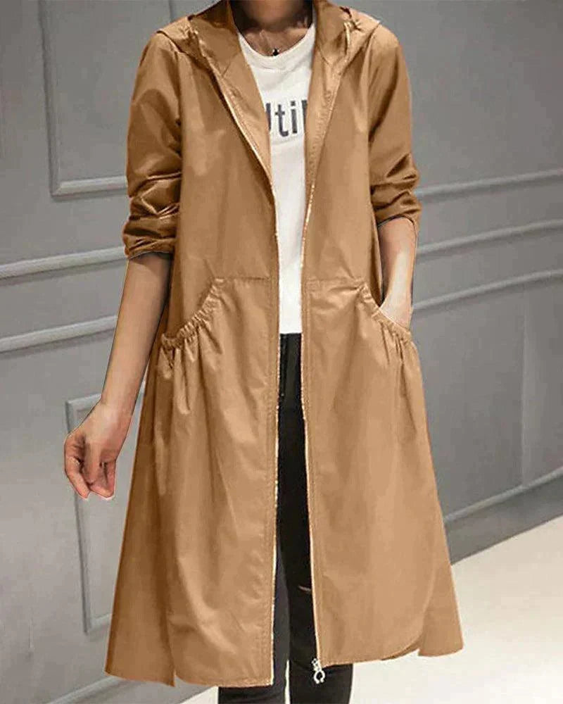 Hooded raincoat in camel brown worn open over a white top and black jeans, with gathered pockets 3