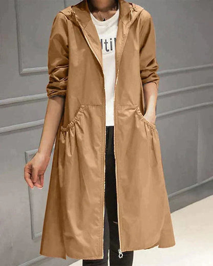 Hooded raincoat in camel brown worn open over a white top and black jeans, with gathered pockets 3