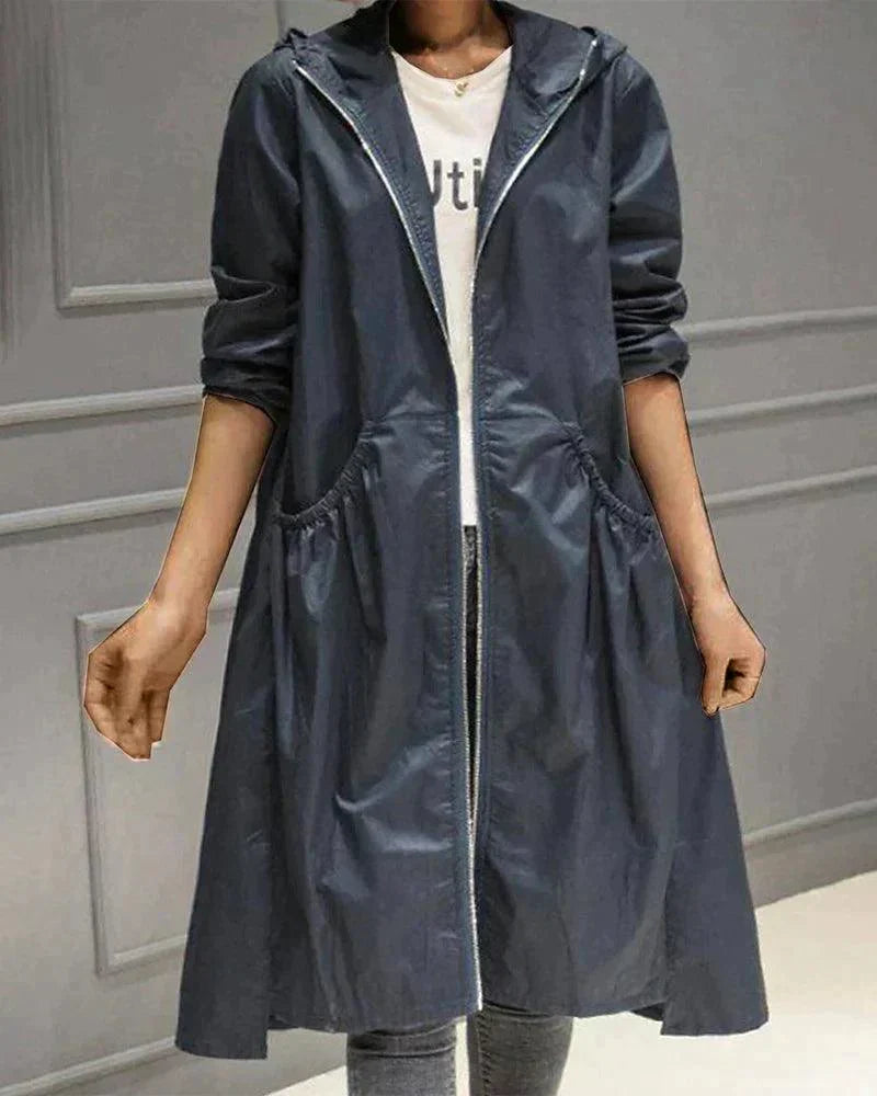Navy blue hooded raincoat worn open with a glossy finish, showing zip edges and gathered pockets 6