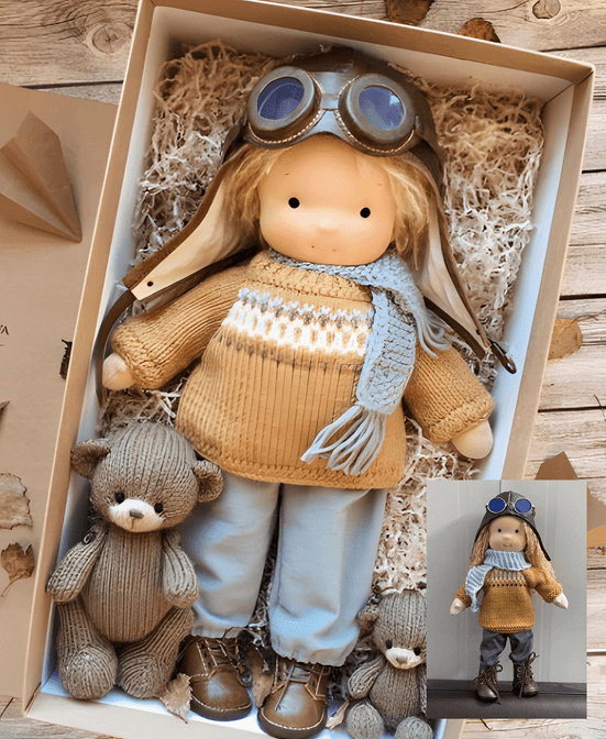 Doll in aviator cap with goggles, mustard knitted jumper and blue scarf, boxed beside two knitted bears 1