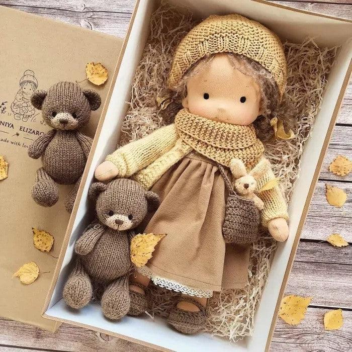 Doll in mustard knitted hat and snood, brown dress and small bag, boxed with two knitted brown teddies 6