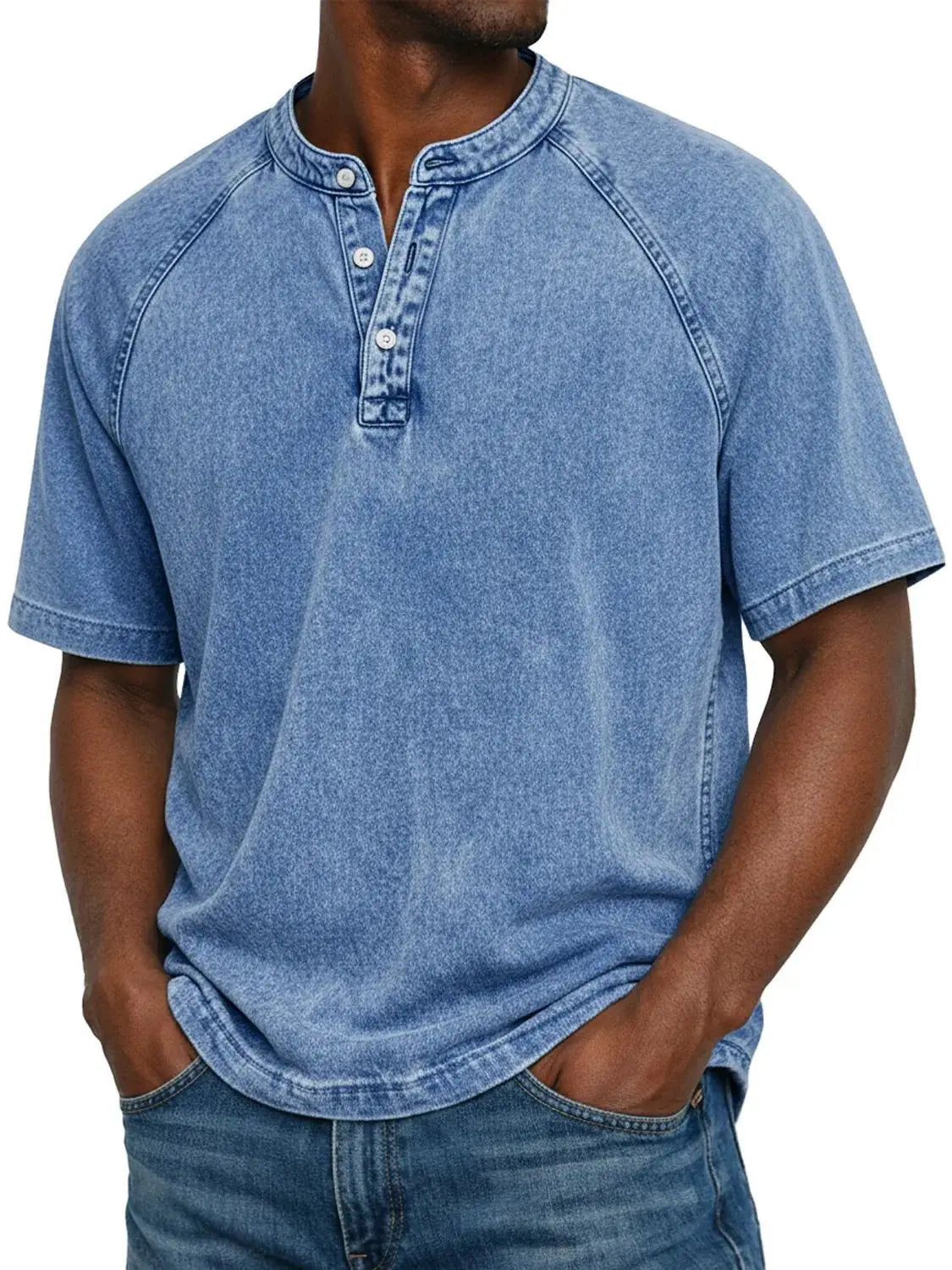 Model wearing the short-sleeved raglan Henley in a washed light blue, with a three-button placket, worn with blue jeans. 2