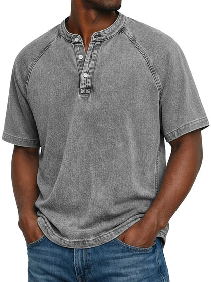 Model wearing the short-sleeved raglan Henley in a washed mid grey, with the three-button placket and round collar visible. 4