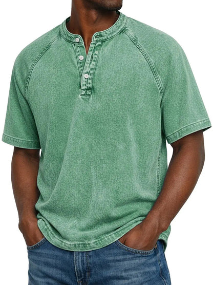 Model wearing the short-sleeved raglan Henley in a washed mint green, with a three-button placket and hands in jeans pockets. 6