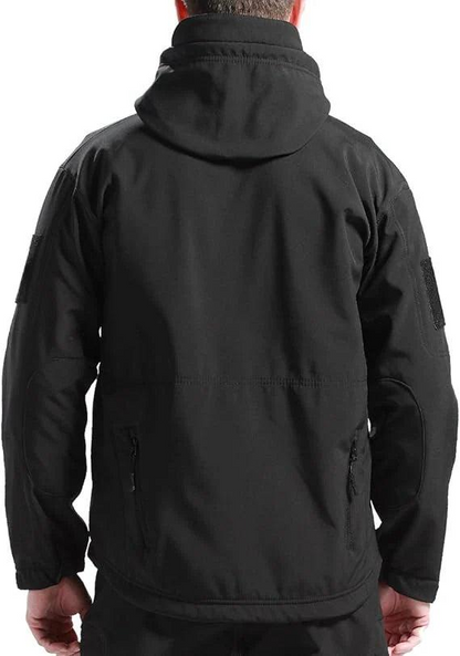 Back view of a man wearing the black hooded jacket, showing the hood, sleeve patches and zipped lower pockets. 7