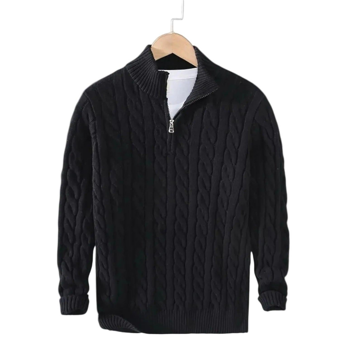Black cable knit jumper with ribbed mock neck and short silver zip, hanging on a wooden hanger over a white top. 2