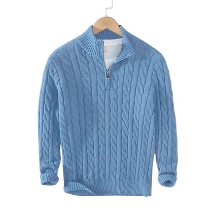 Light blue cable knit jumper with ribbed mock neck and short zip, shown on a wooden hanger against a white background. 3