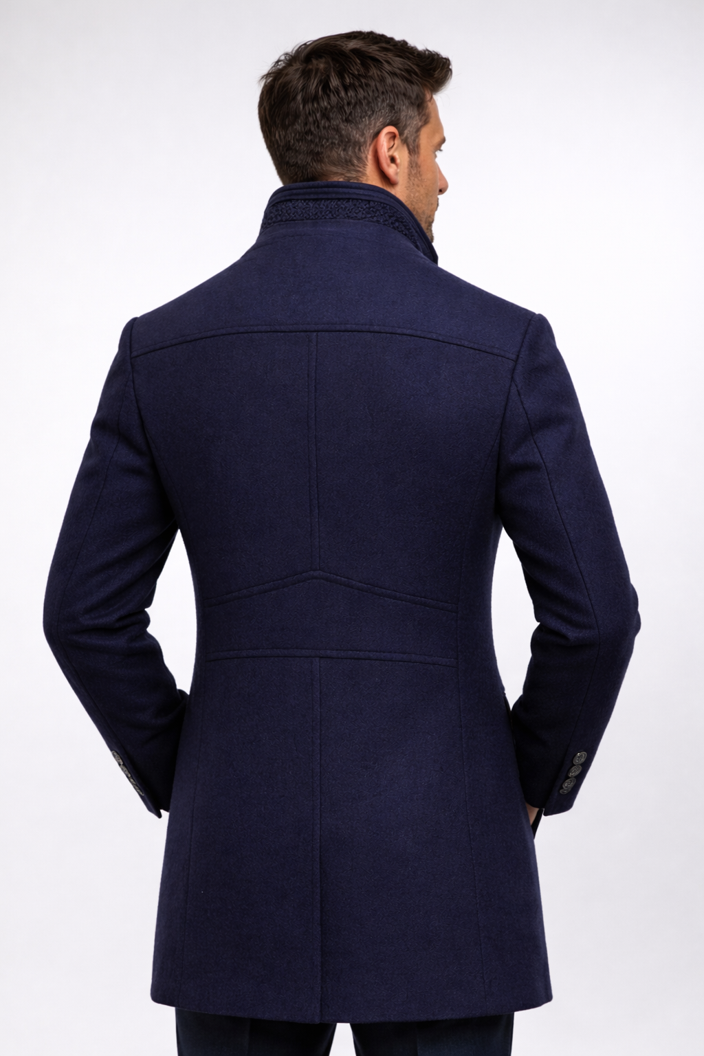 Man seen from behind wearing the navy coat, showing the back panel seams and cuff buttons 14