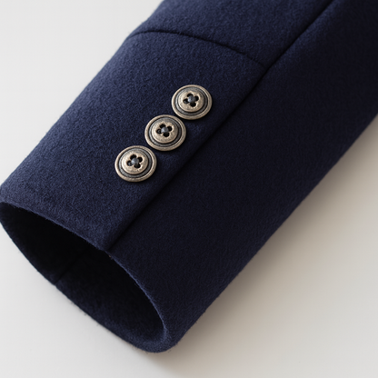 Close-up of a navy sleeve cuff with three small metal buttons in an antique finish 7