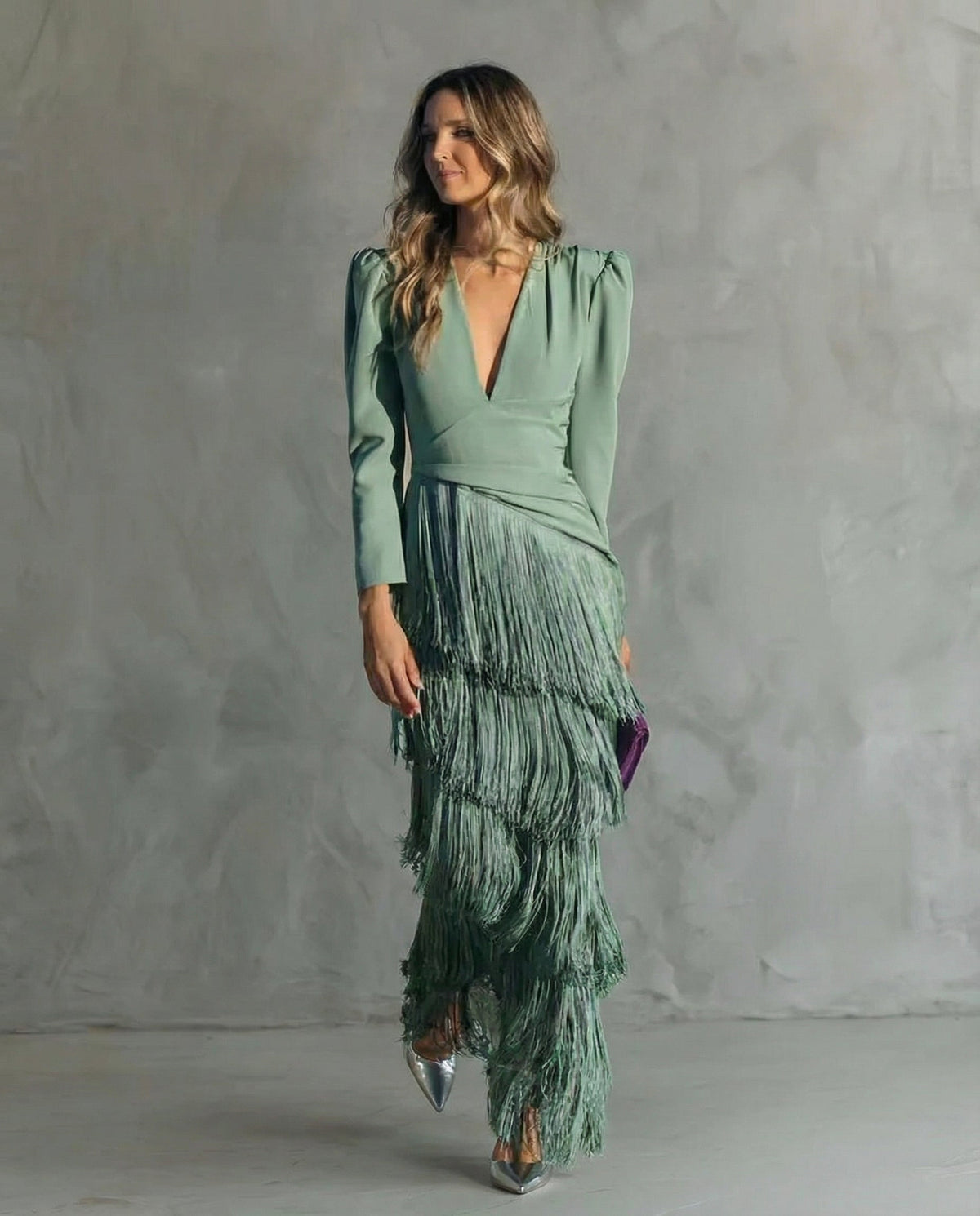Full-length front view of the sage green dress on a model, with layered fringe skirt and silver heels 2