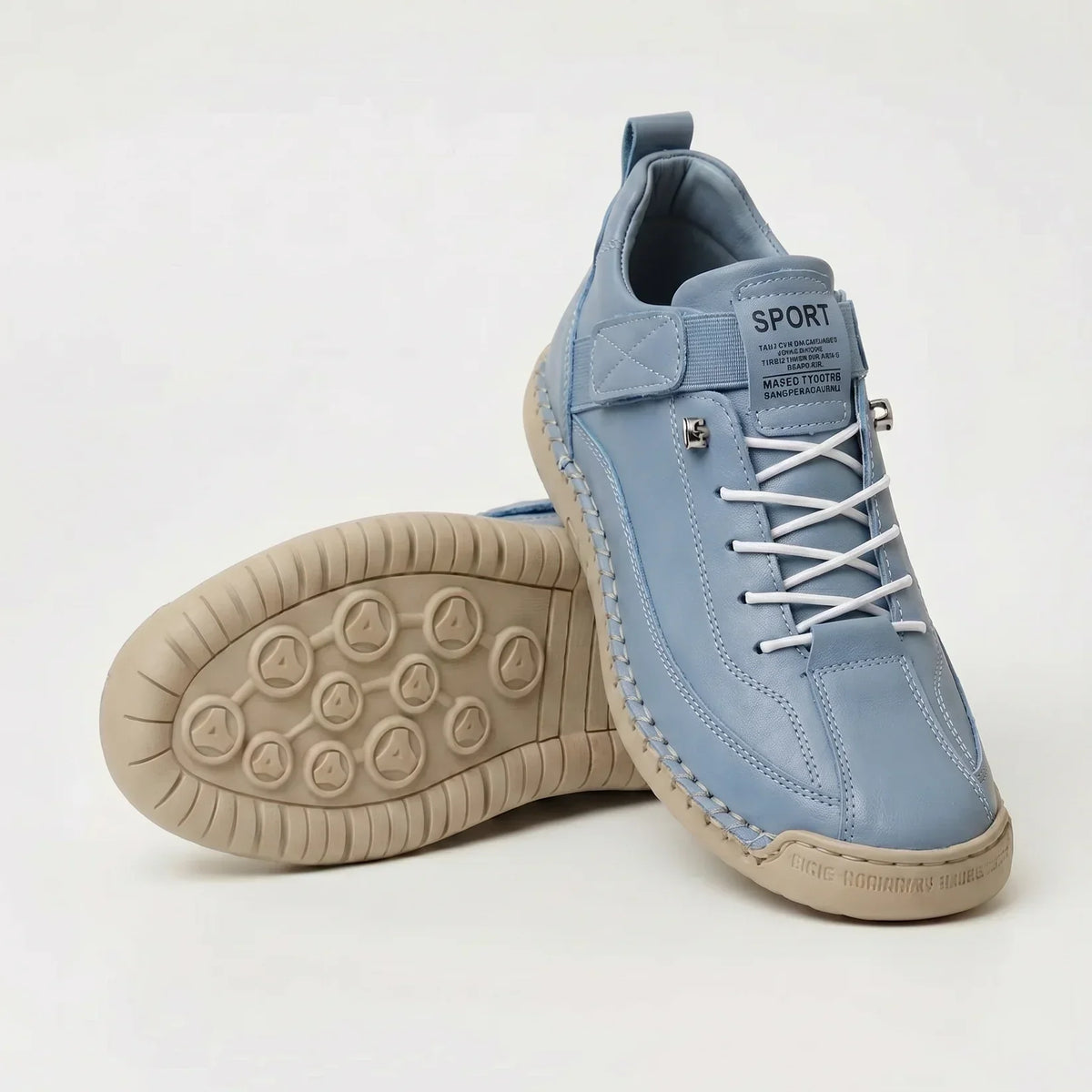 Pale blue lace-up trainers with white elastic laces and beige sole, one shoe standing and one showing the circular studded underside. 11