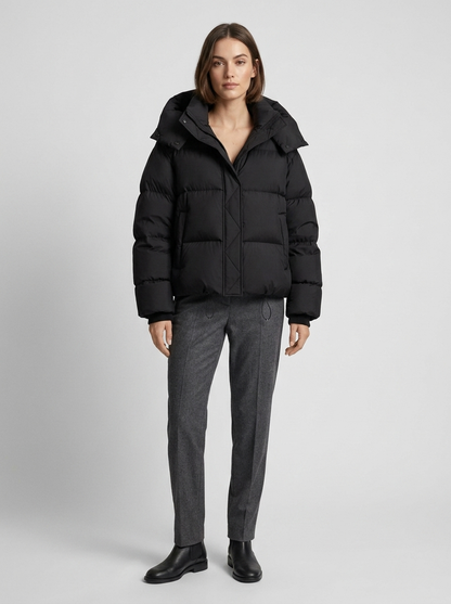 Model wearing the black puffer jacket zipped up with grey tailored trousers and black ankle boots 4
