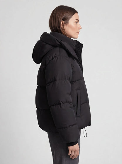 Side view of a model in the black puffer jacket, showing the hood, side pocket and padded sleeve 5