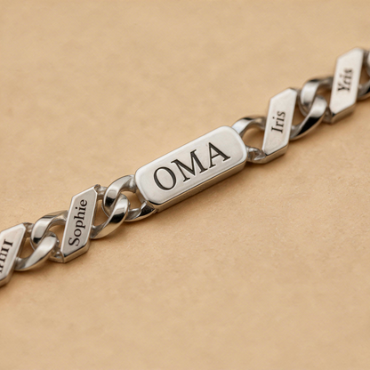 Close-up of the silver chain's engraved central bar and neighbouring name links, showing the crisp black lettering on polished metal. 8